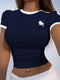Navy blue crop top with white logo worn by a person against a light background