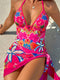 Woman wearing a colorful floral swimsuit on a sandy beach.