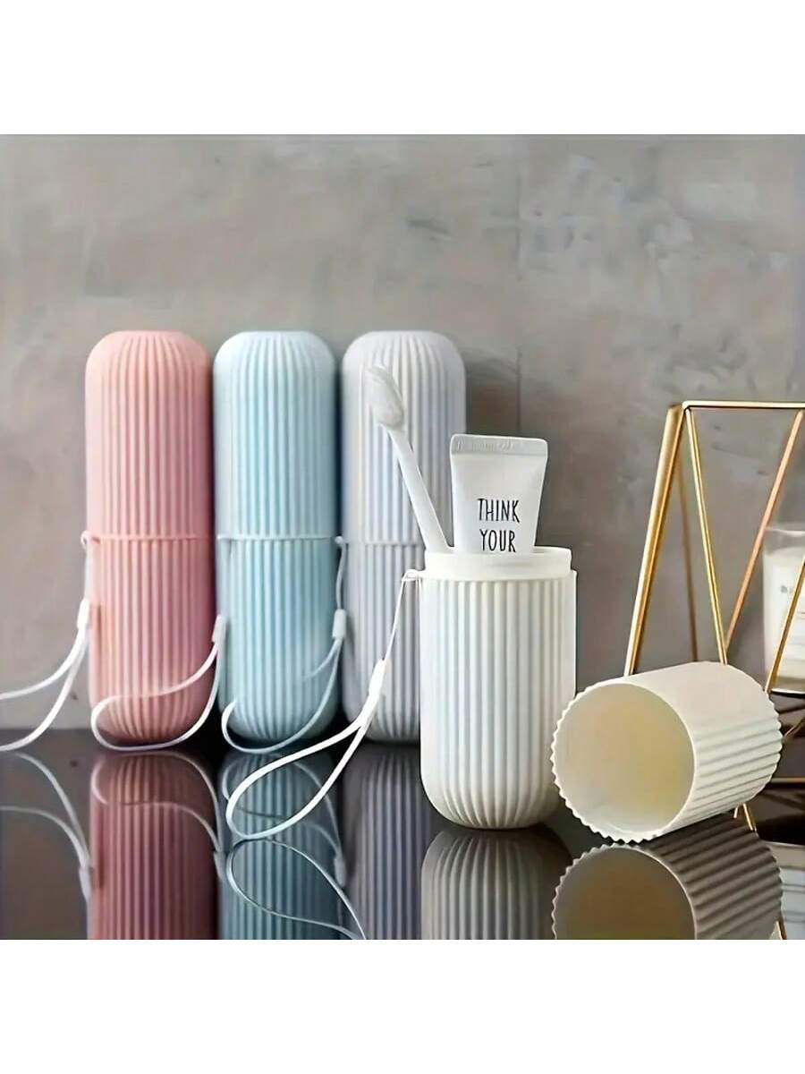 Set of ribbed toothbrush holders in pink, blue, and white on a reflective surface with a neutral background.