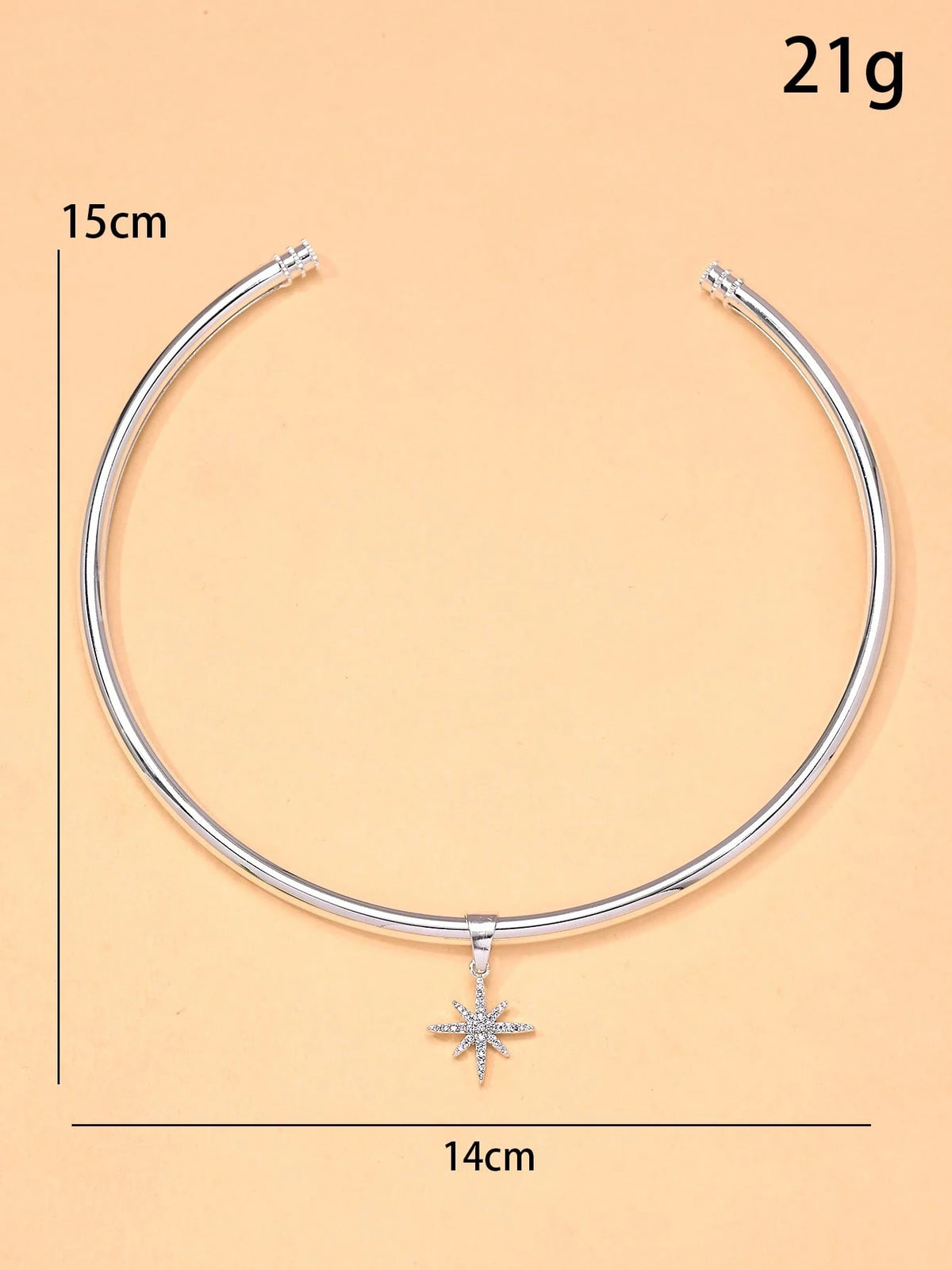 Silver necklace with a star pendant on a beige background