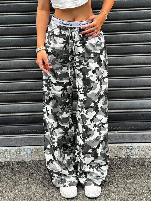 Person wearing camouflage pants and white sneakers standing in front of a metallic shutter.