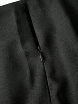 Close-up of a black jacket with a zipper detail on a dark background
