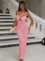 Woman in a pink crochet dress standing on a staircase