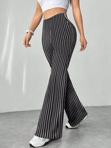 Person wearing black and white striped pants on a plain background